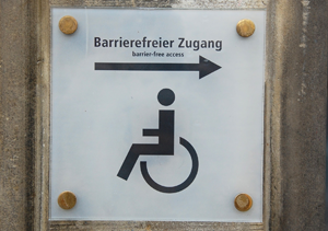 Schild auf welchem barrierefreier Zugang steht und ein Rollstuhl abgebildet ist. Behindertengerecht.